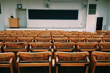 pexels-photo-207691-207691 An empty lecture hall featuring wooden chairs and a large blackboard.